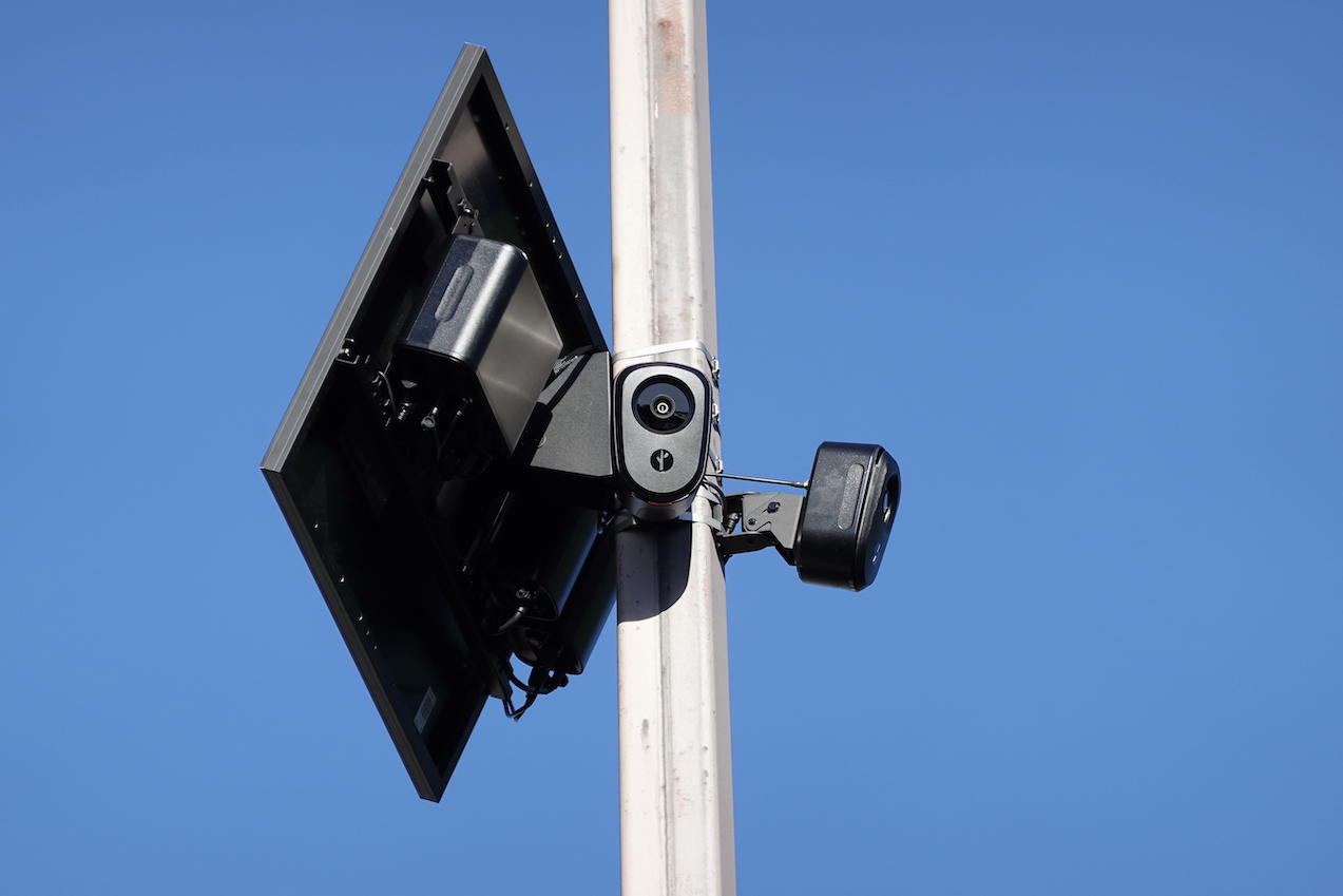 Two Flock safety cameras at 90 degrees on a pole with a solar panel