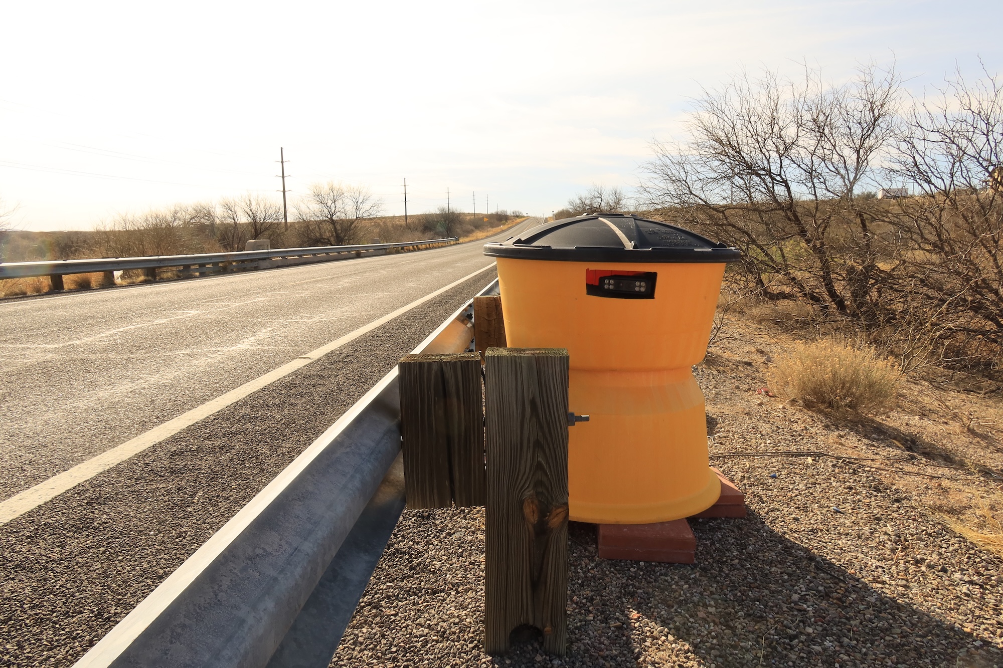 A camera hidden in a yellow sand barrel. 